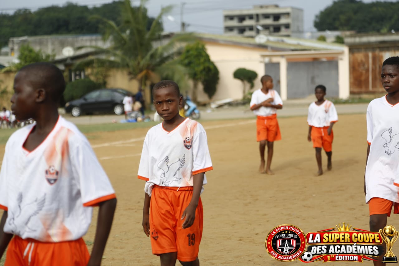 Jeune joueur en tenue blanche et orange sur le terrain